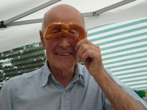  Mann schaut lachend durch Brezen